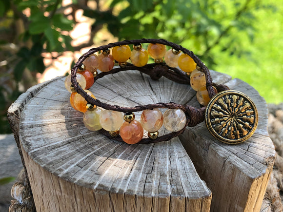 Brown thread bracelet with yellow and orange stones and golden beads