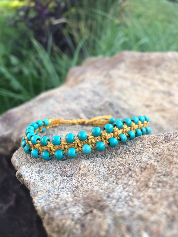 A bracelet of small turquoise beads with a macrame clasp