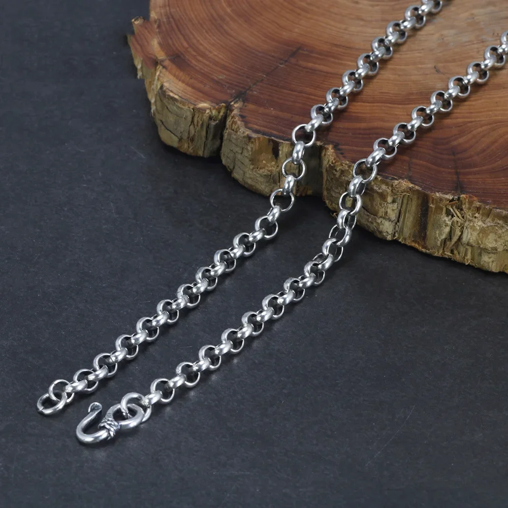 Silver chain on a wooden block with a dark background