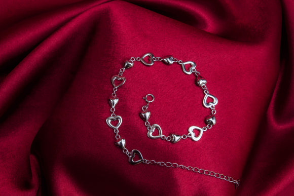A sterling silver bracelet with hollow and solid hearts. Length: 18 cm + 5 cm extension