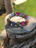 Grey thread bracelet with green, purple and pink stones