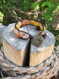 Brown thread bracelet with yellow and orange stones and golden beads