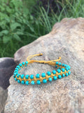 A bracelet of small turquoise beads with a macrame clasp