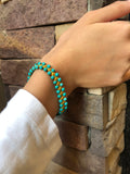 A bracelet of small turquoise beads with a macrame clasp