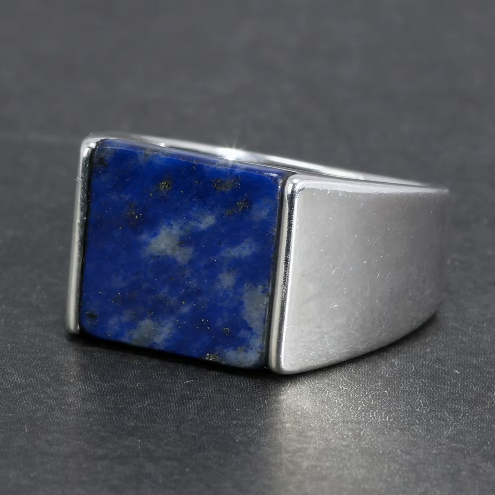 Silver ring with a blue stone on a dark gray background