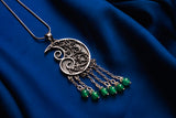 Snail pendant with green stones