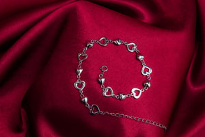 A sterling silver bracelet with hollow and solid hearts. Length: 18 cm + 5 cm extension