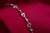 A sterling silver bracelet with hollow and solid hearts. Length: 18 cm + 5 cm extension